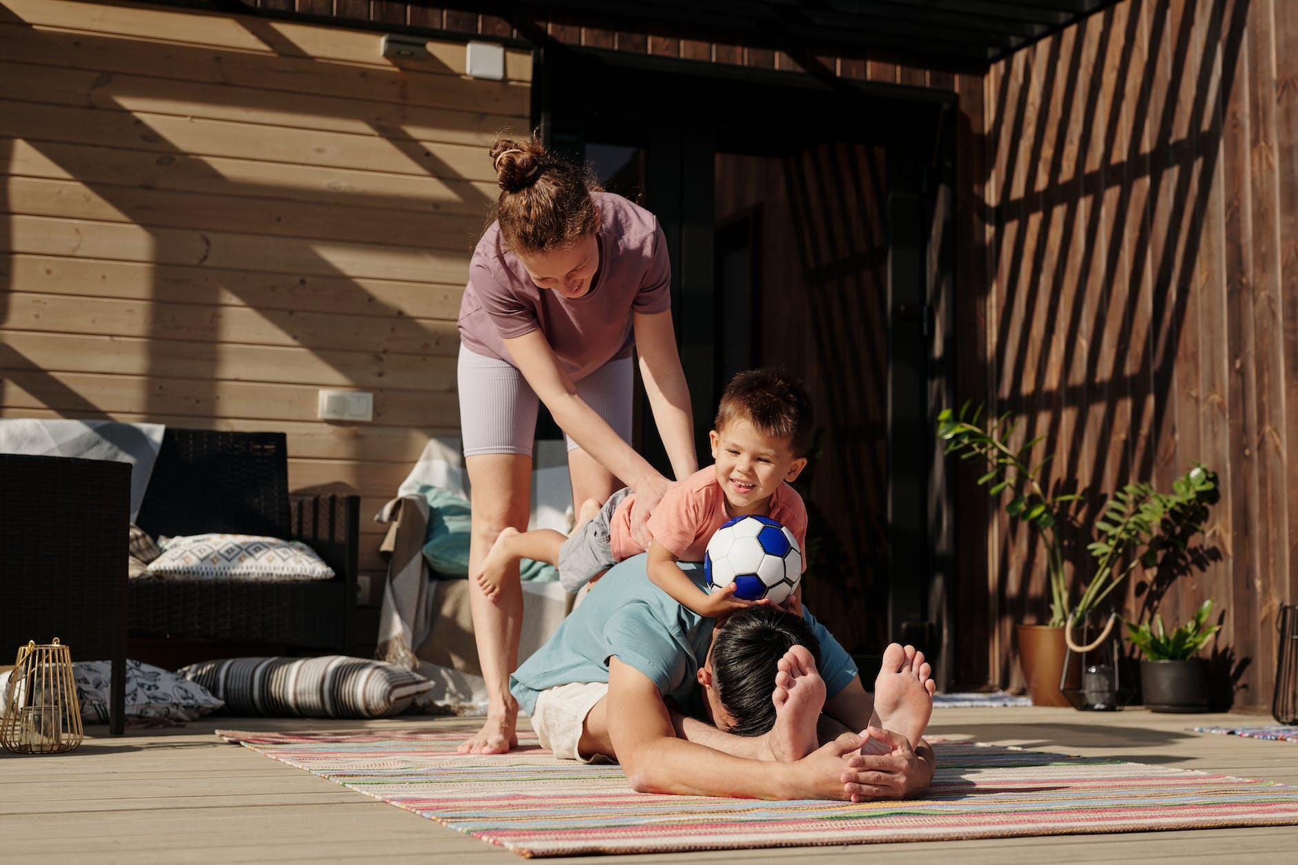 A family (mother, son and father) trying yoga in the outside